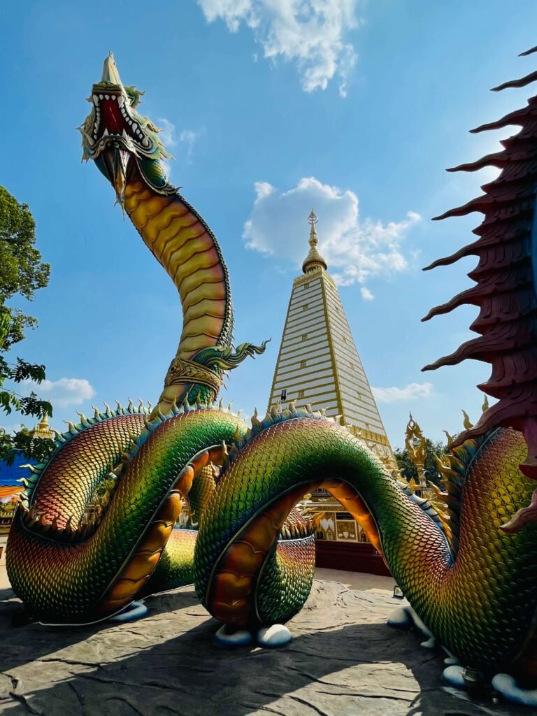 Entrée majestueuse du temple Wat Sirindhorn Wararam avec ses motifs colorés et illuminés la nuit.