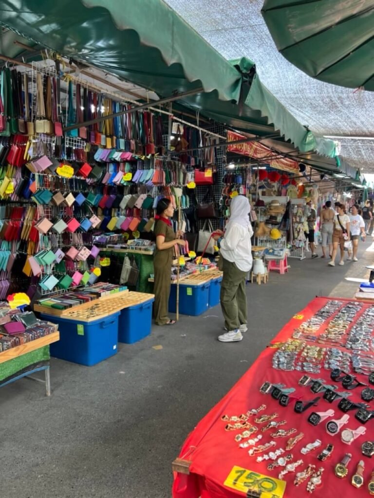 Vue d’un stand d’artisanat au marché Chatuchak, où les visiteurs peuvent acheter des souvenirs et des objets d’art.