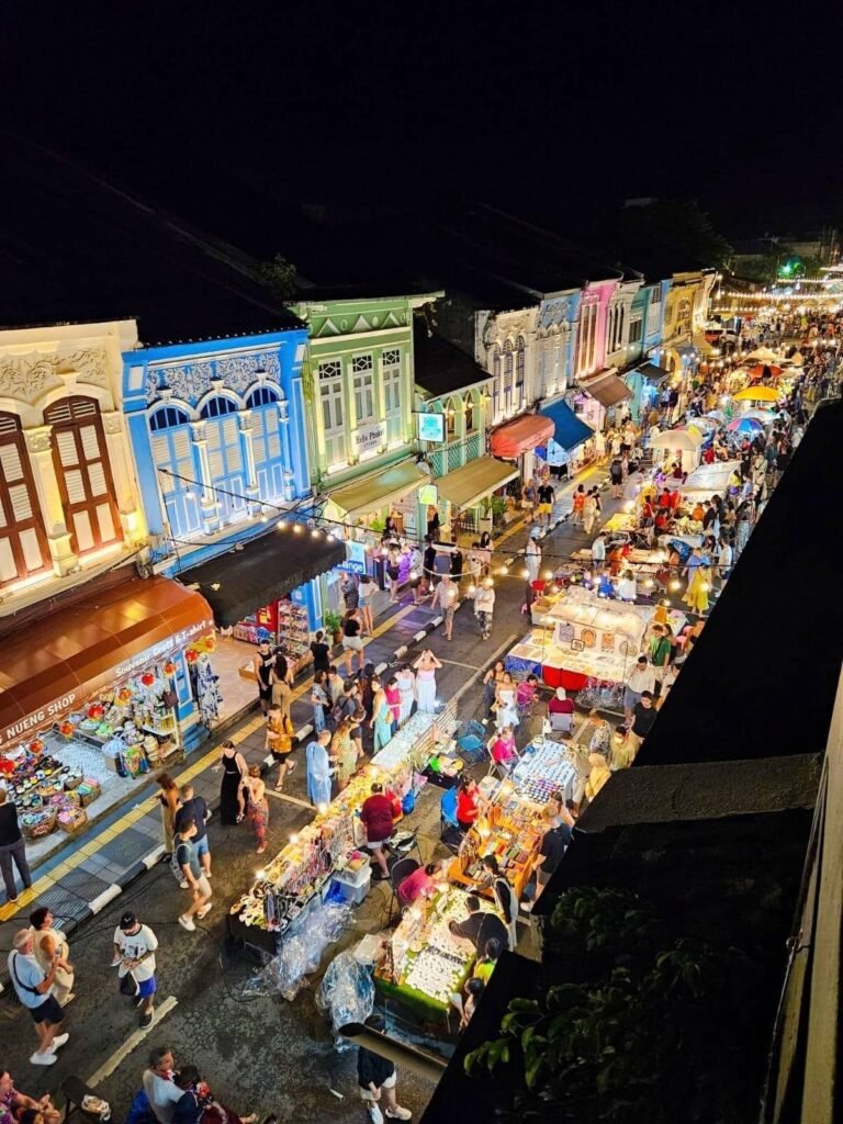 Vue aérienne du marché du dimanche soir à Phuket Town, avec ses stands illuminés et ses bâtiments aux façades colorées.