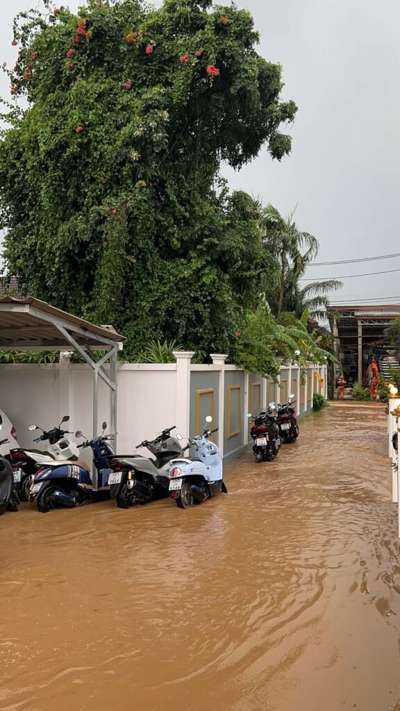 itinéraire pour un premier voyage
Rue inondée en Thaïlande pendant la saison des pluies, avec des motos garées le long du mur.