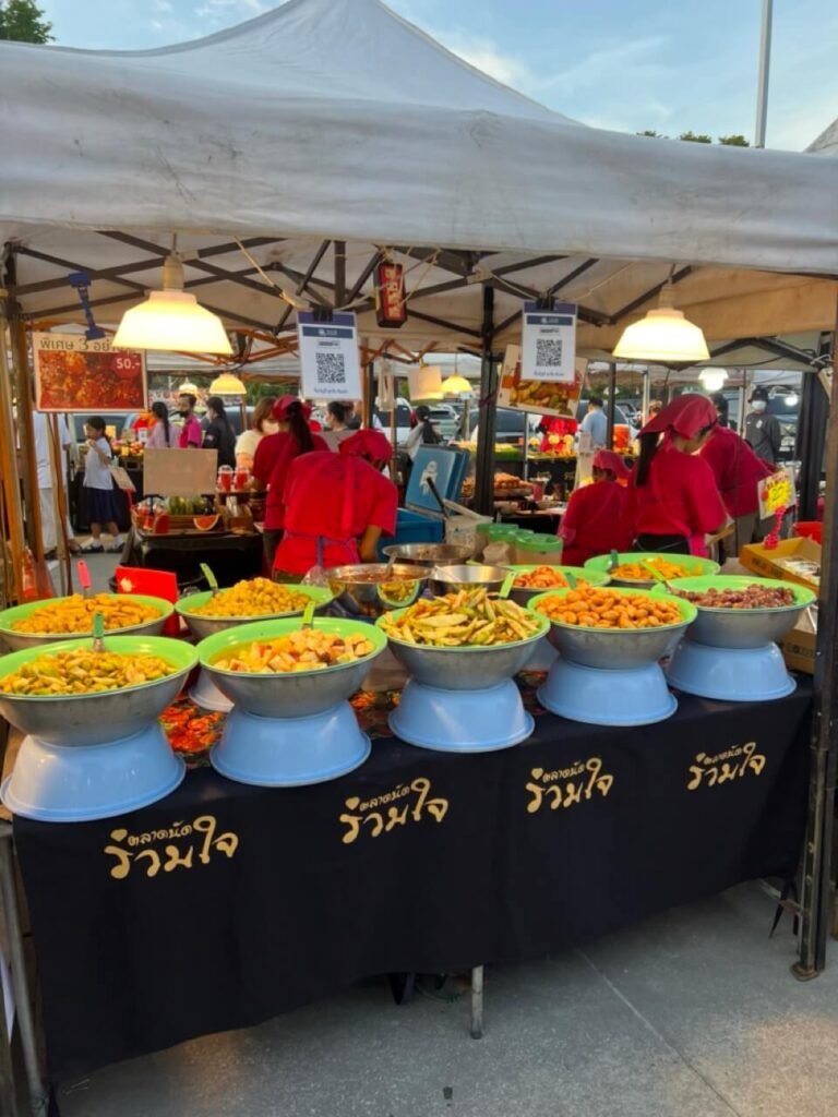 Buffet de street food en Thaïlande avec des plats typiques comme le pad thaï et le som tam, des repas économiques.